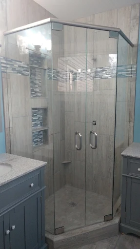 Frameless glass corner enclosure beside a vanity